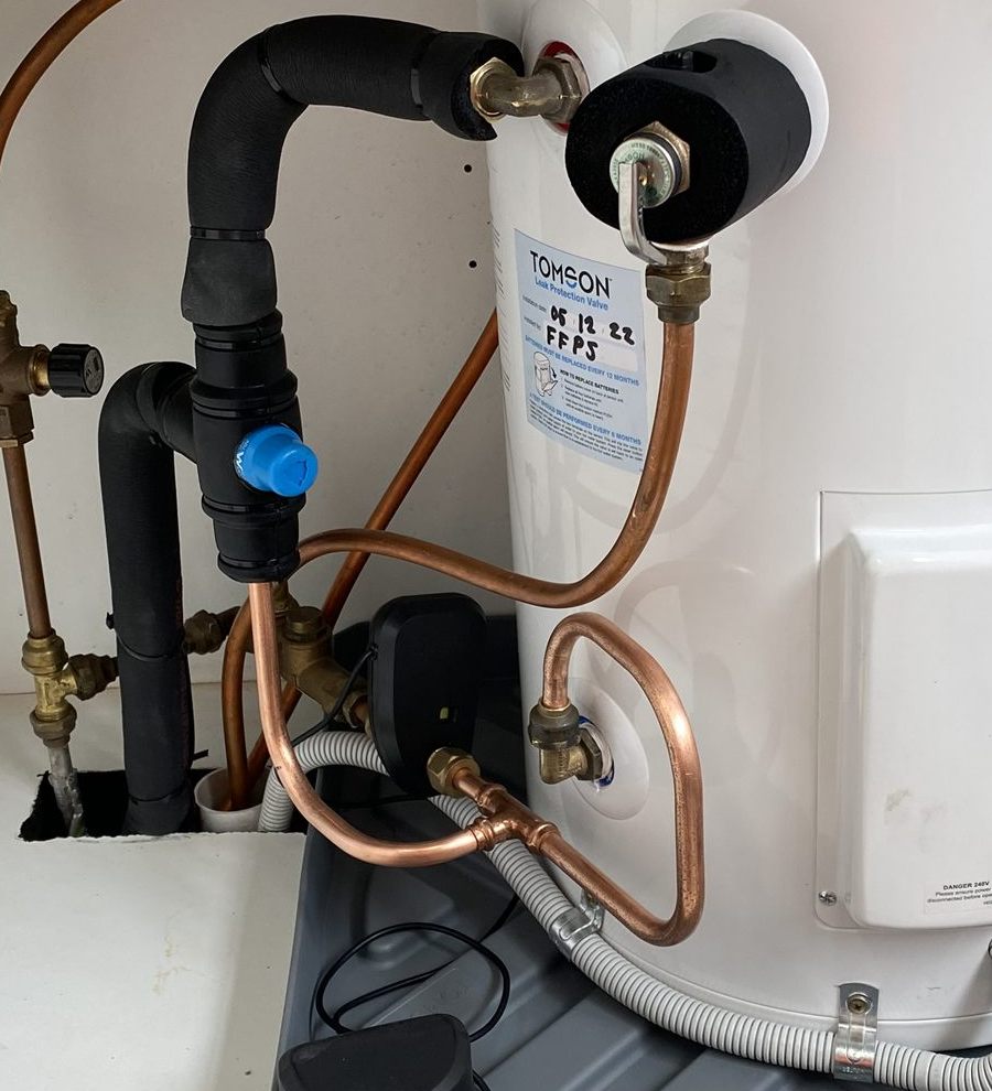 Close-up of a leak protection valve with the install date and FFPS initials handwritten on the label